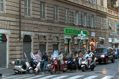 Scooters voor een stoplicht; Scooter-drivers waiting for a traffic-light